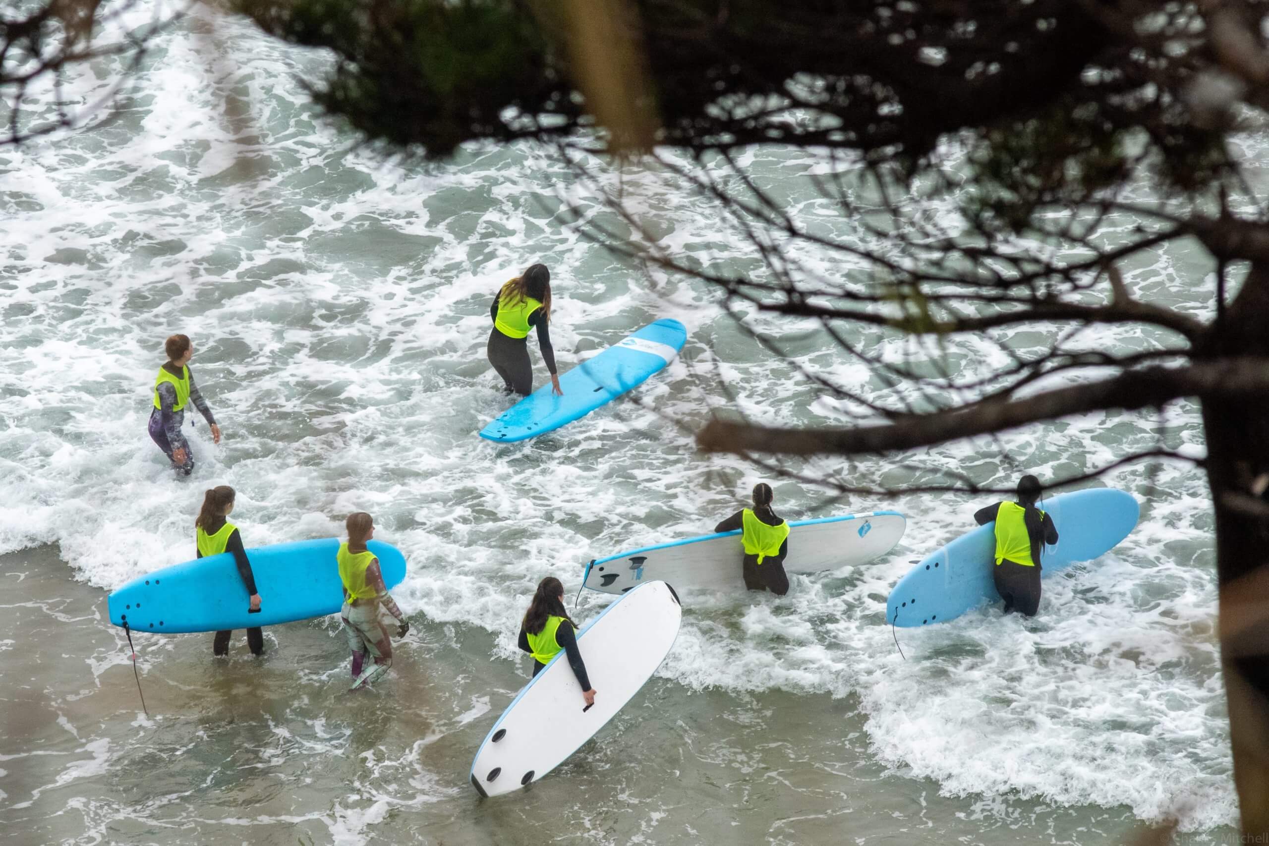 All Are We Collective getting into the water with boards